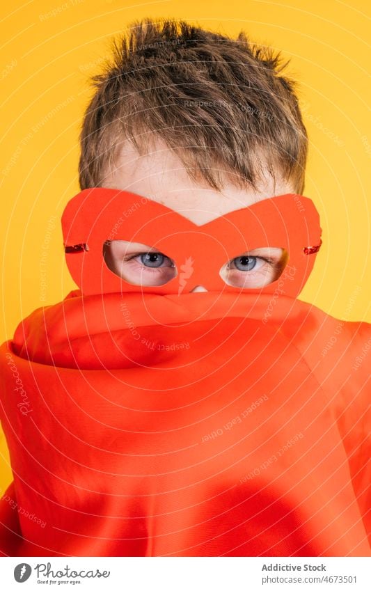 Junge mit Superheldenmaske und Umhang, der das Gesicht bedeckt Kind Tracht Mundschutz Vorschein Deckblatt Tierhaut Porträt Atelier Kraft Mut Held selbstbewusst
