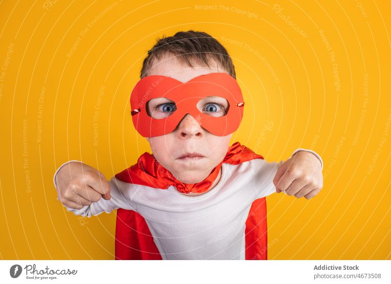 Junge im Superhelden-Outfit zeigt Muskeln Kind Erfolg Sieg erreichen Gewinner Tracht Atelier Porträt Mut Kraft Ehrgeiz Mundschutz Bizeps Held selbstbewusst