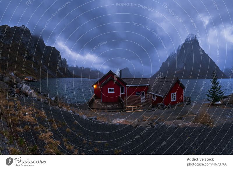 Stürmischer Himmel über dem Meer und felsiges Ufer mit Hütten MEER stürmisch Berge u. Gebirge Natur atemberaubend Norwegen Insel lofoten Wasser Klippe Küste