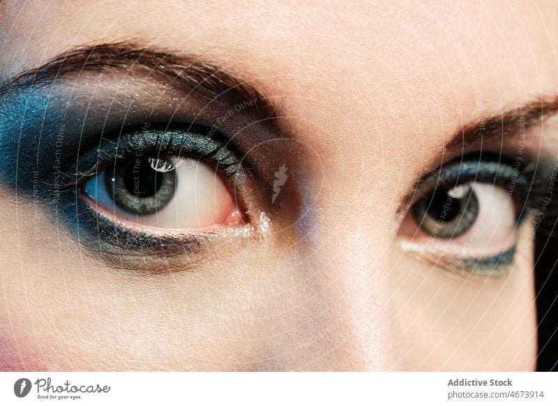 Attraktive Frau mit hellem Make-up Auge Lidschatten Kosmetik Stil Mode Vorschein Gesicht Starrer Blick Model Glitter farbenfroh glänzend Kajal Licht trendy