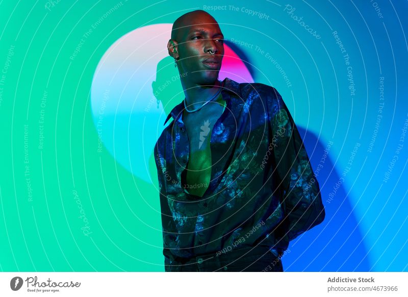Modischer schwarzer Mann im Studio Stil Mode Licht trendy modern Design leuchten Outfit Kleidung Vorschein selbstbewusst glühen Atelier Afroamerikaner ethnisch