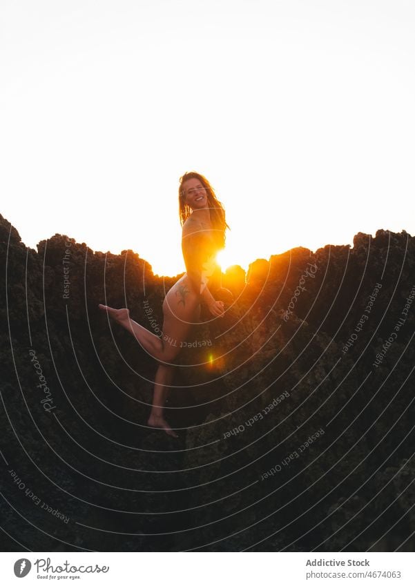 Unerkennbare nackte Frau auf Felsen stehend sexuell Verlockung MEER Sonnenuntergang Yoga Asana Wasser Figur provokant verführerisch Natur Abend sinnlich schlank