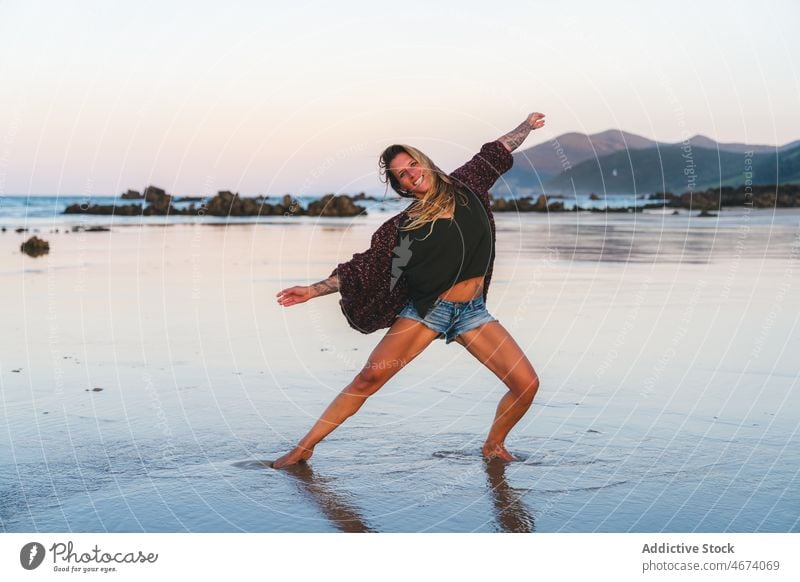 Fröhliche Frau tanzt am nassen Strand Tanzen Wasser Ufer Küste Natur MEER Erholung Aktivität Sommer sich[Akk] bewegen Dame Glück aktiv heiter positiv