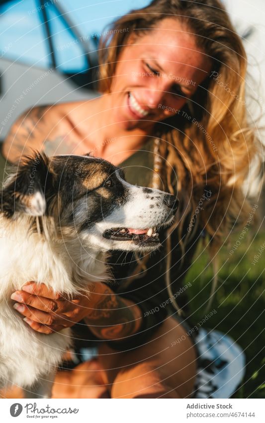 Lächelnde Frau streichelt Australian Shepherd Hund Besitzer Australischer Schäferhund Haustier Tier Straße Umarmung Streicheln züchten Reinrassig Eckzahn
