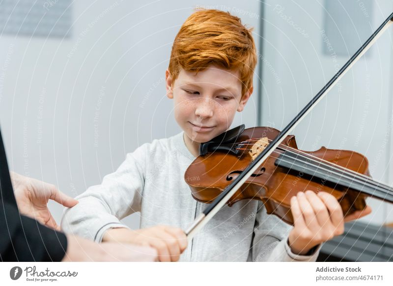 Lächelnder Junge spielt Geige in der Musikschule spielen Lektion Melodie Kind Klasse Musiker Schule heiter lernen Talent üben Inhalt Glück Klassenraum