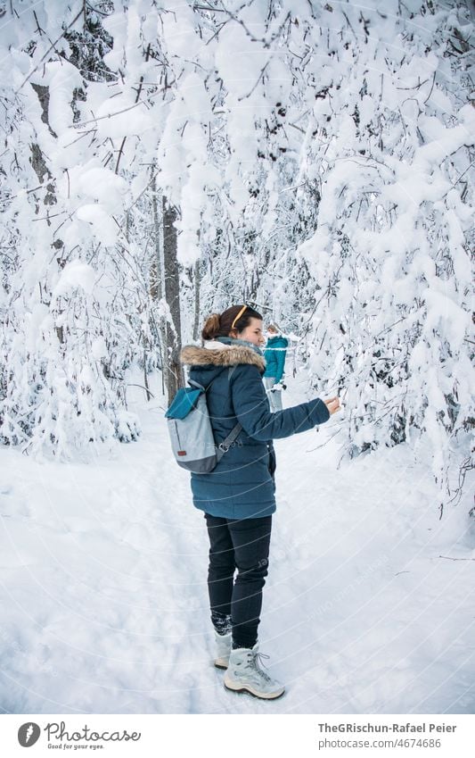 Frau spaziert im Schnee im Wald Baum verschneite Bäume Spaziergang kalt Winter weiß gefroren Schweiz