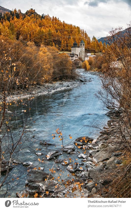 Fluss vor Kirche im Herbst - Engadin Wasser Bäume Lerchen Schweiz tourisumus Landschaft Berge u. Gebirge Außenaufnahme Farbfoto Baum