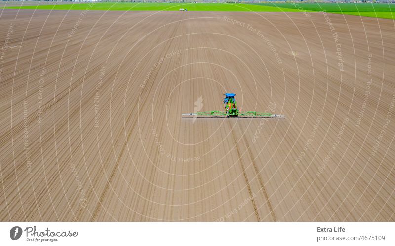 Luftaufnahme eines Traktors beim Besprühen eines Feldes mit Sprühgerät, Herbizid und Pestizid oben Antenne Aerosol landwirtschaftlich Ackerbau anbaufähig