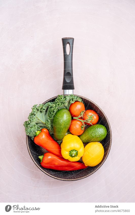 Bratpfanne mit verschiedenem rohen Gemüse gesunde Ernährung Paprika Avocado Tomate Suppengrün organisch Vitamin Bestandteil reif frisch Küche natürlich Rezept