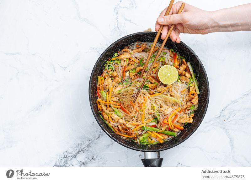 Anonyme Person, die gebratene Reisnudeln mit Gemüse isst essen Essstäbchen Rührbraten Nudel Mahlzeit kulinarisch Küche Lebensmittel lecker geschmackvoll Speise