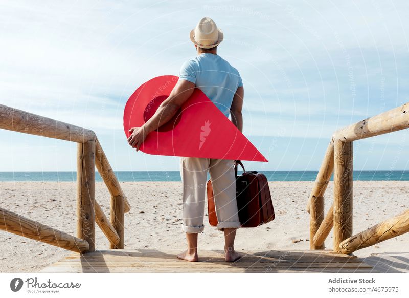 Reisender mit rotem Kartenzeiger auf der Strandpromenade Mann Stecknadel Landkarte Zeiger verirrt Örtlichkeit Regie Tourist Promenade Suche Tourismus reisen