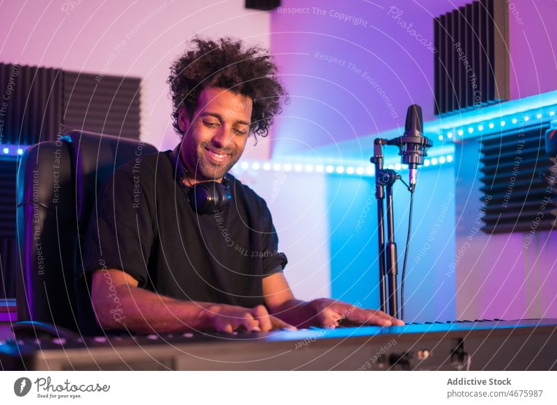 Schwarzer Mann spielt Klavier in einem modernen Aufnahmestudio Musiker spielen Aufzeichnen Atelier Lächeln Glück Gesang Talent Melodie männlich ethnisch schwarz