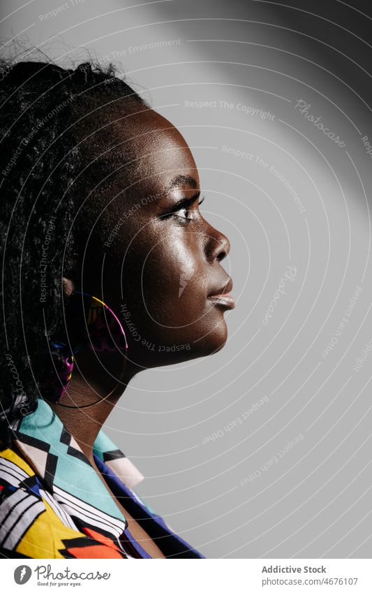 Seitenansicht Porträt einer schwarzen Frau mit lockigem Haar kurvenreich Afroamerikaner ethnisch Stil trendy Vorschein Afrikanisch farbenfroh krause Haare