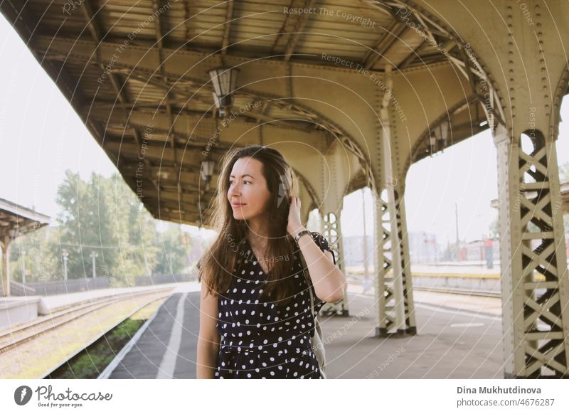 Junge stilvolle Millennial Frau zu Fuß an einem alten Bahnhof warten auf Zug. Schöne Frau Tourist in lässigen Kleid in der Stadt zu reisen. Transport schön