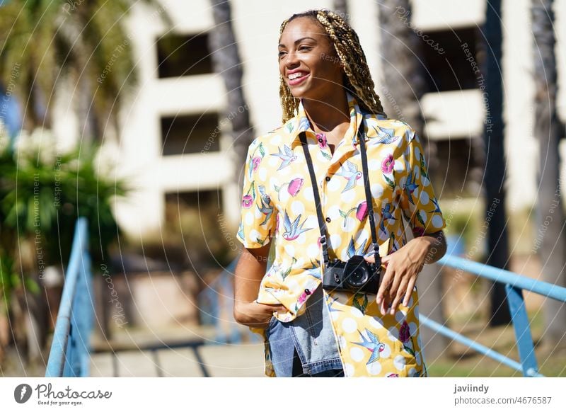 Lächelnde schwarze Frau mit Fotokamera in der Stadt Fotograf Fotoapparat Sommer Großstadt Stil Straße positiv Fotografie Afroamerikaner ethnisch cool Inhalt