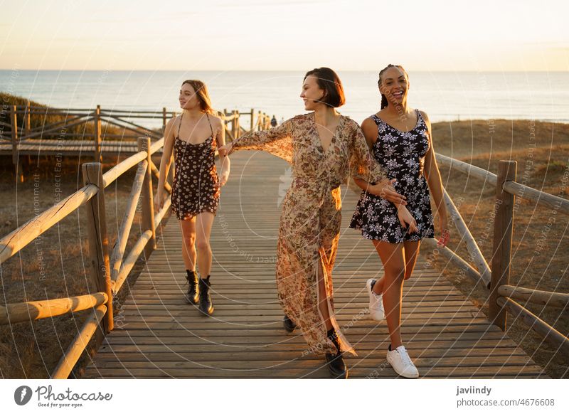 Fröhliche diverse Freundinnen gehen auf einem Steg in der Nähe des Meeres spazieren Frauen Seeküste MEER Strand Ufer Freizeit Bonden Ausflug Hafengebiet