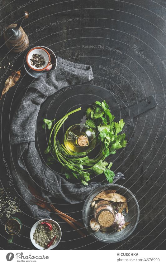 Lebensmittel Hintergrund mit Petersilie, Olivenöl, runde schwarze Schneidebrett, Gewürze Küchenutensilien dunkel Küchentisch Essen zubereiten heimwärts frisch