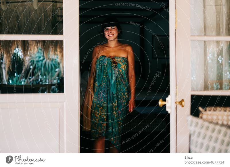Eine Frau in buntem sommerlichen Tuch steht in der geöffneten Terrassentür und lächelt. Sommer Badetuch Kleid bung Sommerurlaub Tropen Erholung Urlaub Hotel