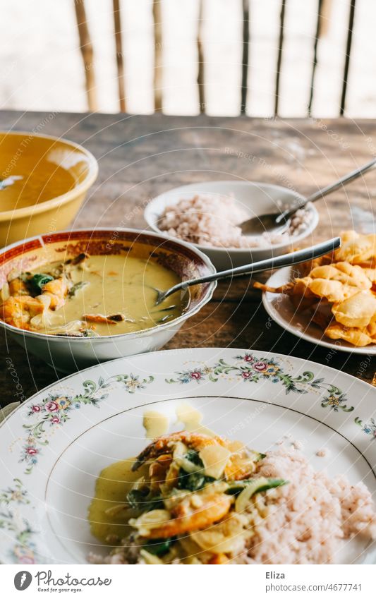 Gelbes Garnelencurry mit Reis und sri-lankischen Papadams auf einem Holztisch Curry gelb Sri Lanka Essen lecker scharf Schüssel Mahlzeit asiatisch frisch