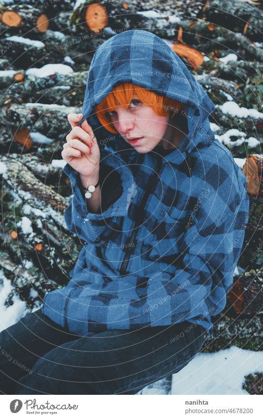 Rothaariges androgynes Modell in einer Winterszene Menschen Teenager queer nicht-binär jung Jugend kalt Kapuze Kapuzenpulli Rotschopf warm Wärme thinkg allein