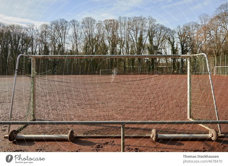 Blick durch ein Tor auf ein anderes auf einem roten Fußballplatz aus Asche Aktivität Hintergrund Schlacke Club Tag Übung Feld Fußballtraining Boden horizontal