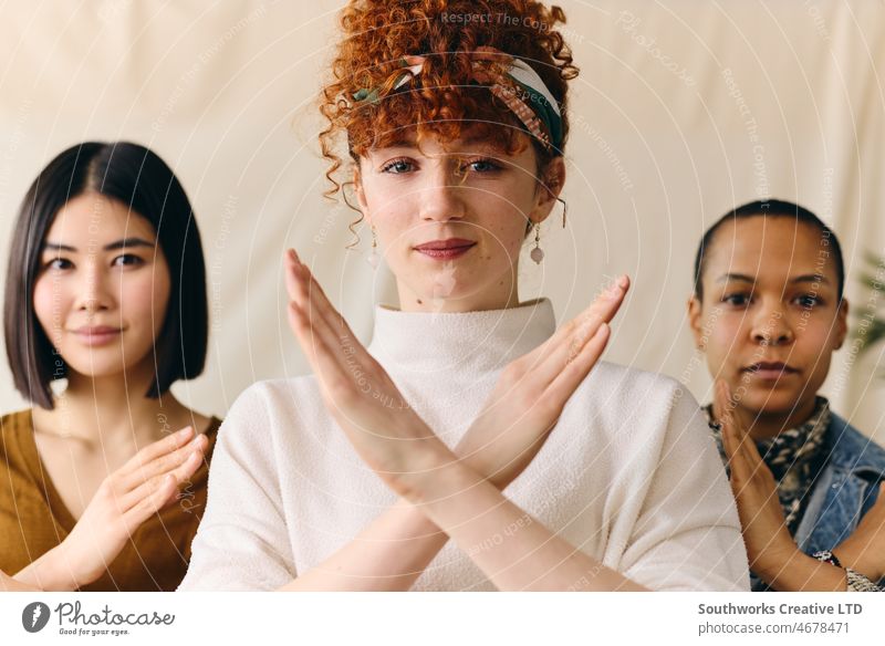Junge weiße Frau mit Geste "Break The Bias" zur Unterstützung des Internationalen Frauentags mit multiethnischen Freundinnen Internationaler Frauentag iwd