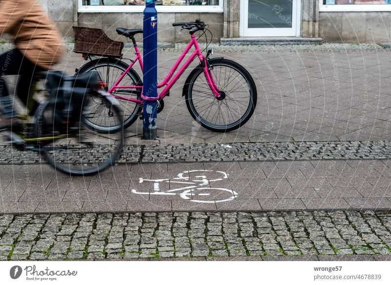 Fahrradweg mit Radler und am Laternenpfahl gesicherten Rad in der City 2/2 Stadt angeschlossen Verkehr Fahrradfahren Straßenverkehr Mobilität Außenaufnahme
