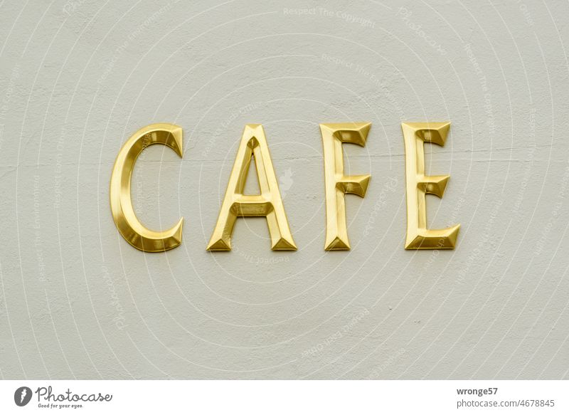 CAFE in goldenen Buchstaben an einer Hauswand Cafe Café Großbuchstaben Fassade Häuserwand Häuserfront Schriftzeichen Menschenleer Farbfoto Typographie Wort
