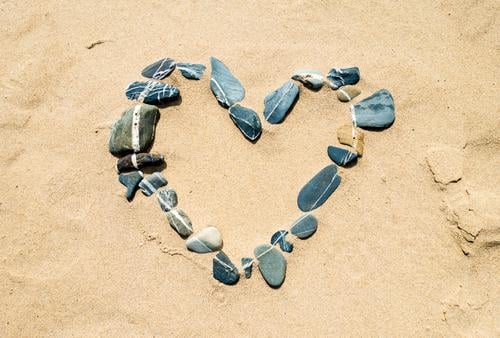 Herz aus Steinen im Sand ZEICHEN naturmaterial sand stein steine symbol zuneigung herzlich positive Emotion romantisch lieben verlieben verliebt sein Liebe