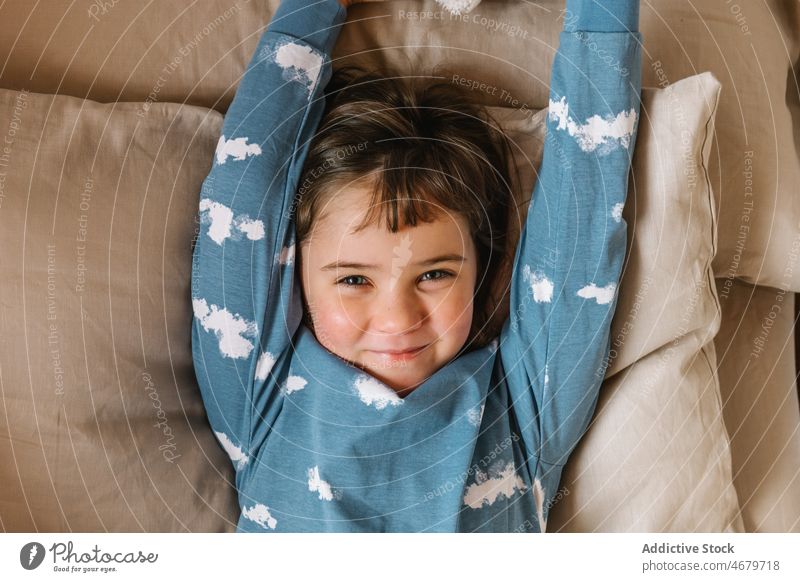 Heiteres Mädchen im Pyjama auf dem Bett liegend Kind Kindheit Schlafzimmer Morgen heimisch Schlafenszeit gemütlich Appartement bezaubernd flach niedlich