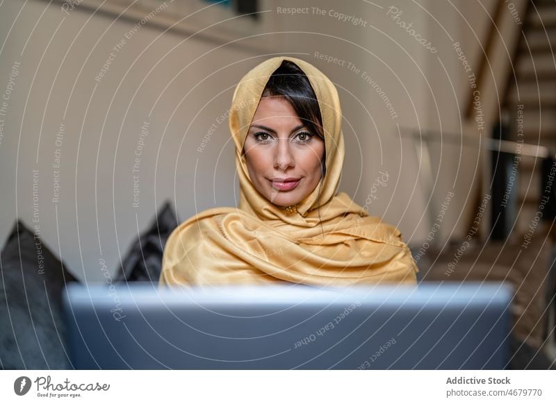 Muslimischer Freiberufler benutzt Laptop zu Hause Frau freiberuflich benutzend heimwärts abgelegen Projekt online Daten Tradition klug Erwachsener ethnisch