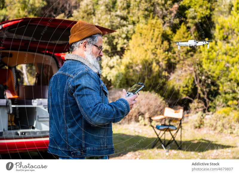 Älterer Mann steuert Drohne auf dem Land Kontrolle Fernbedienung arbeiten Dröhnen uav älter Wohnmobil Landschaft Wald reif Reisender Kleintransporter Ausflug