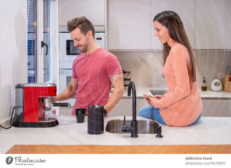 Fröhliches Paar bei der Kaffeezubereitung in der Küche Kaffeemaschine Maschine Koffein Vorrichtung Küchengeräte brauen Heißgetränk geschmackvoll vorbereiten