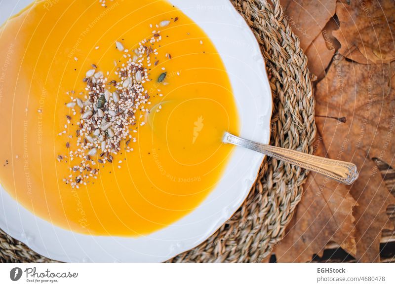 Close up Teller mit Kürbissuppe Creme mit einem Herbst Hintergrund von Blättern und Holz abschließen Farben Koch Kopie Sahne Rahmsuppe cremig dekorativ dine
