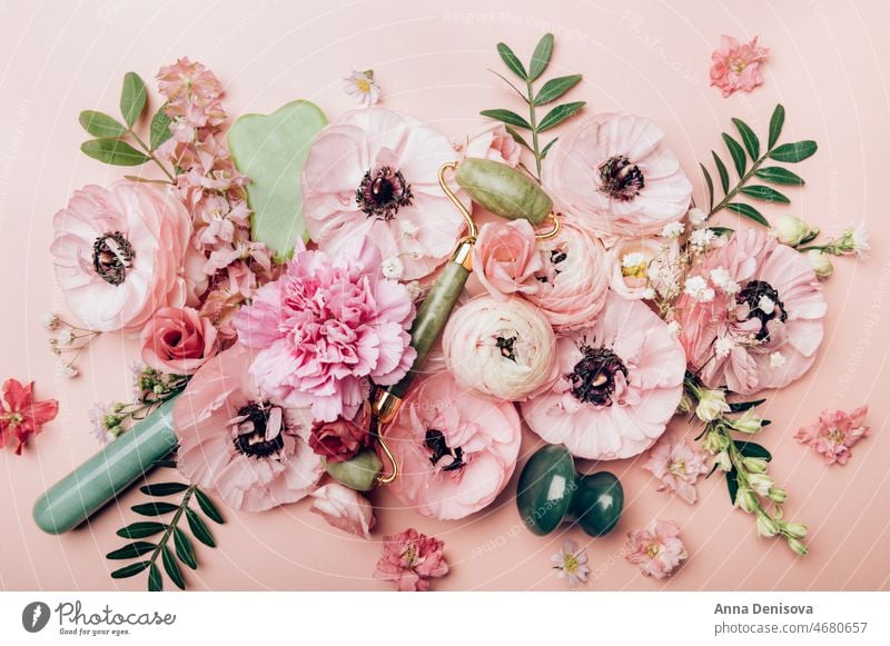 Blumenarrangements aus zarten Ranunkelblüten Ranunculus Blumenstrauß trendy Kosmetik Gesicht Pflege Stein Laufrolle Jade-Walze Guasha-Akupunktur-Behandlung