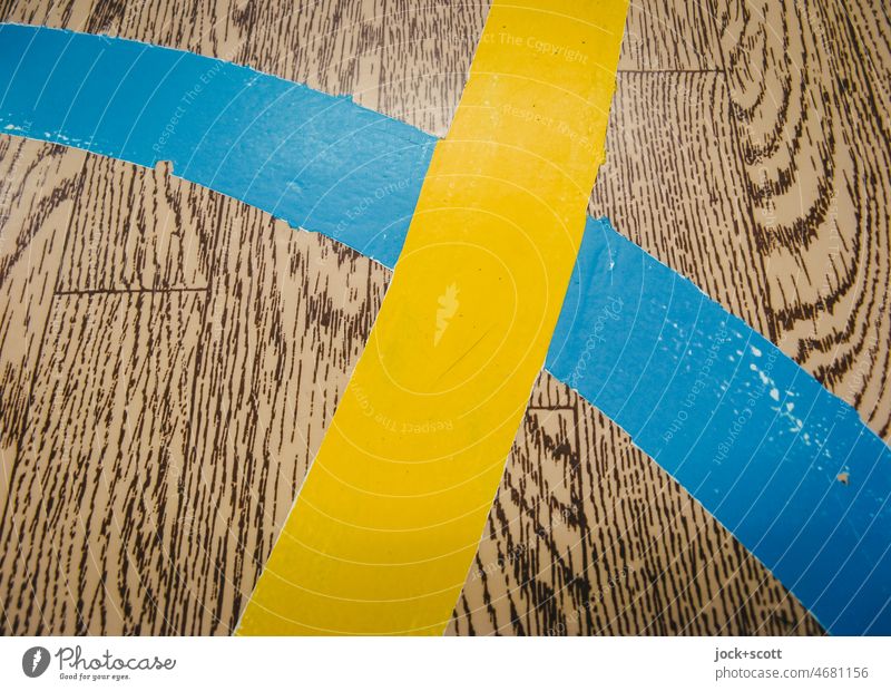 Blaue und Gelbe Linie kreuzen sich DDR Detailaufnahme Bodenbelag Strukturen & Formen retro Markierungslinie Linienstärke Holzimitat abstrakt Holzimintat PVC
