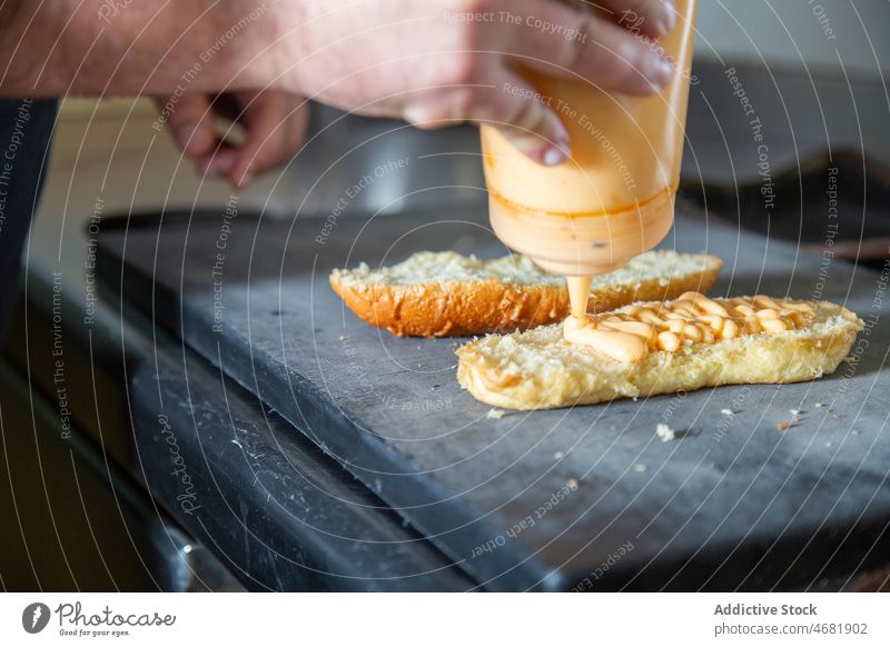 Gesichtsloser Koch gießt Soße auf Brot Mann Küchenchef Bruschetta Saucen kulinarisch Rezept Restaurant Arbeit vorbereiten Abfertigungsschalter Job professionell