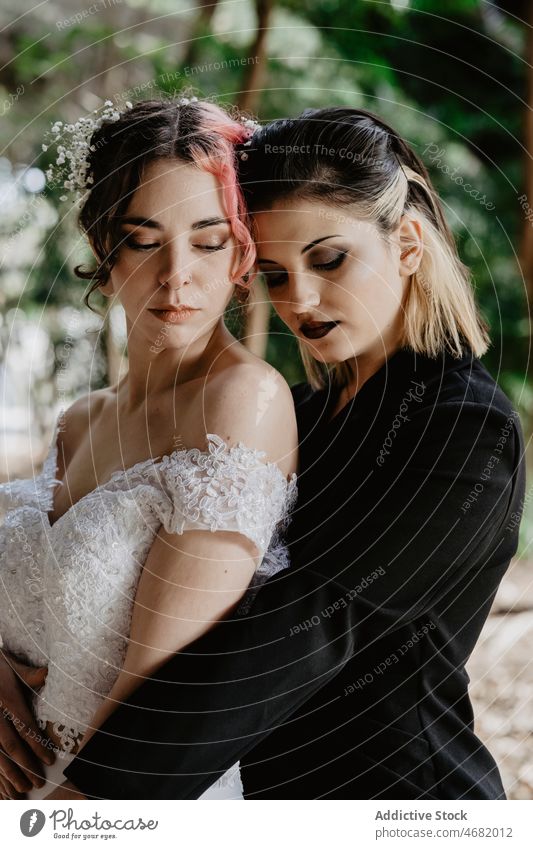 Neuvermähltes Paar homosexueller Frauen im Sommergarten Jungvermählter lesbisch lgbt Hochzeit Augen geschlossen Umarmung Liebe Homosexualität ausgefallen Park