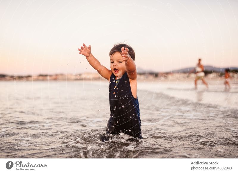 Niedlicher Junge geht im Meer Kind Wasser MEER spielerisch Kindheit Freizeit Zeitvertreib Resort Ufer niedlich Sommer bezaubernd unschuldig platschen Erholung