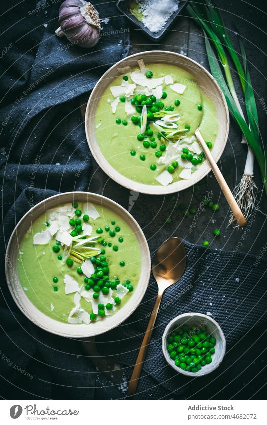Erbsencreme auf dunklem Tisch Sahne Suppe kulinarisch Gastronomie Küche Püree Mahlzeit gesunde Ernährung Lebensmittel grün Zwiebel Löffel Serviette dienen