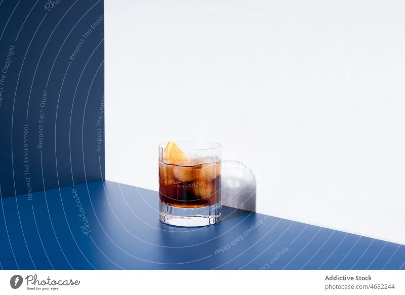 Roter Wermut im Glas serviert auf blauem und weißem Hintergrund rot Alkohol Cocktail orange dienen Getränk Schnaps Aperitif trinken Zitrusfrüchte Portion Frucht