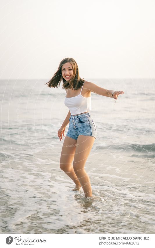 Glückliche Frau lächelnd am Ufer des Strandes Waffen Freiheit friedlich Sonnenschein Windstille Person hübsch Lächeln Sommerzeit Sonnenlicht sorgenfrei Inhalt