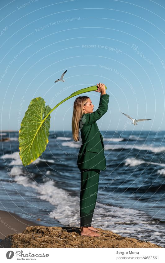 Fine Art Fotografie einer eleganten kaukasischen Frau am Strand mit einem großen grünen Blatt künstlerisch Künstler Kunst Frieden Wasser Barfuß Spanien Europa