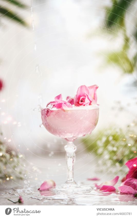 Crystal Champagner Glas mit fancy rosa Getränk mit Rosenblatt an weißen Tisch mit Blumen Kristalle Sektglas ausgefallen trinken Roséwein Blütenblatt