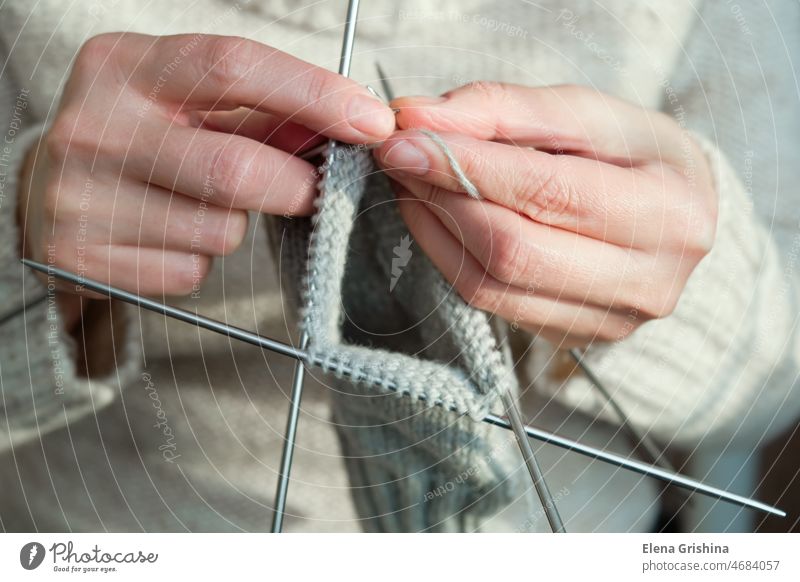 Weibliche Hände halten Stricknadeln und stricken eine Socke. Handmade und Hobby-Konzept. Nadeln Kniestrümpfe Stricker Frau Handwerk selbstgemacht Wolle Garn