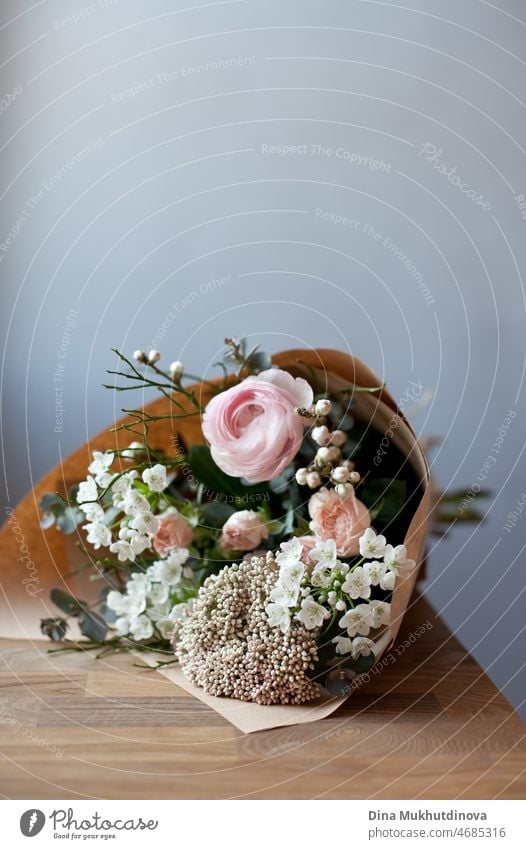 Bouquet von rosa und weißen flowerson Holztisch im Blumenladen. Floristik und Verkauf von Blumen kleines Geschäft. Rosa frischen Frühling floralen Hintergrund mit Kopie Raum auf der Oberseite mit hellgrauem Hintergrund.
