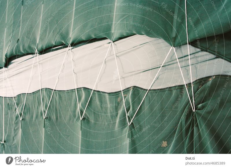 grüne Schutzplane mit Zickzack-Schnur Netz Plane Seil vertäut zickzack zusammenhalten Verpackung Textil Abdeckung verbunden absichern fragil