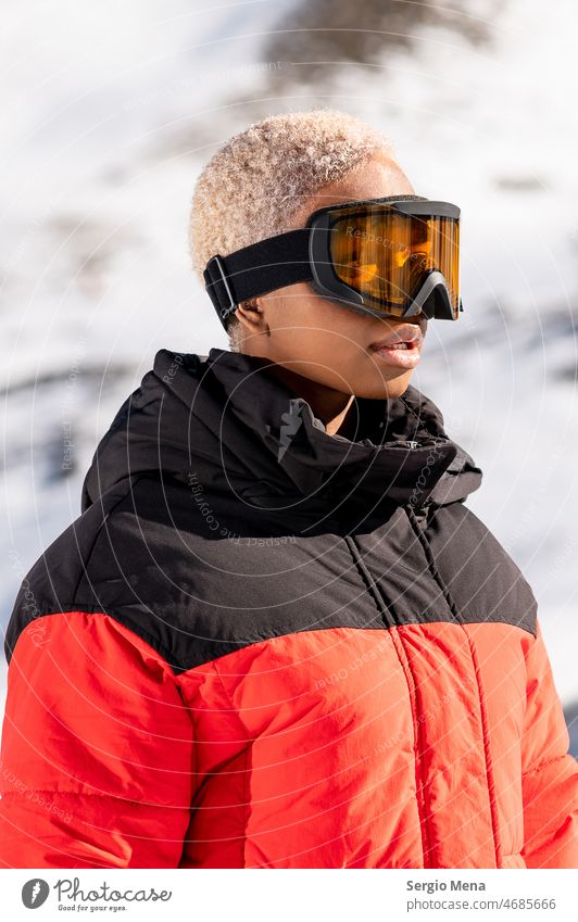 Afroamerikanische Frau mit Schutzbrille in einem verschneiten Berg im Winter stehend schneebedeckter Berg Schneebrille eine Person Afro-Look Amerikaner