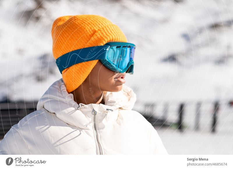 Afroamerikanische Frau mit Schutzbrille in einem verschneiten Berg im Winter stehend schneebedeckter Berg Schneebrille eine Person Afro-Look Amerikaner