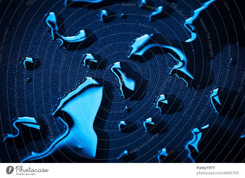 Blaumetallisch glänzende Wassertropfen auf schwarzem Textil Untergrund blau Hintergrund nass Reflexion & Spiegelung Makroaufnahme Nahaufnahme Detailaufnahme